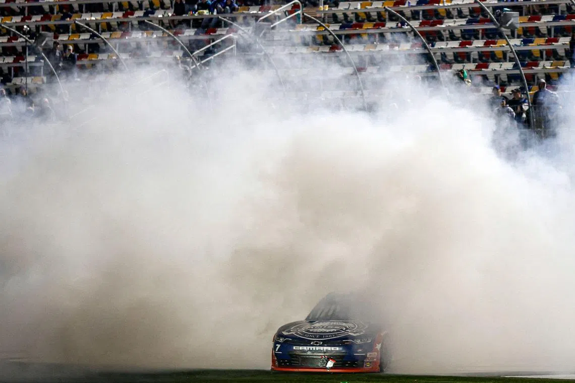 Justin Allgaier, driver of the #7 Unilever Military DeCA RCPT Chevrolet, celebrating with a burnout after winning the NASCAR Xfinity Series Alsco Uniforms 300 at Charlotte Motor Speedway on May 29, 2023.