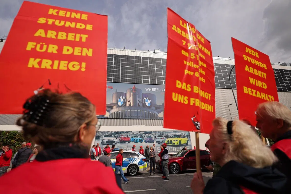 A placard reads ‘Not a single hour work for war’ on a banner during a protest rally as part of the IG Metall Day of Action in Munich on Sept 21.