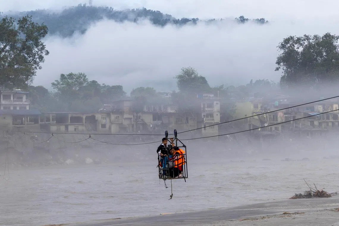 epa13218967 People use a temporary cable bridge, locally known as the Twin Cross, to cross over the Trishuli River following flash floods at Devighat in Nuwakot district, Nepal,07 September 2026. Nepal is observing a national day of mourning on 07 September on the 13th day following devastating flash floods. More than 1,200 people have been killed, and over 4,000 remain missing across northern Nepal after a glacial collapse and avalanche-triggered flash floods and mudslides along the Bhotekoshi and Trishuli river valleys near the Nepal-Tibet border, causing widespread destruction to settlements and infrastructure, according to the National Disaster Risk Reduction and Management Authority (NDRRMA).  EPA/NARENDRA SHRESTHA
