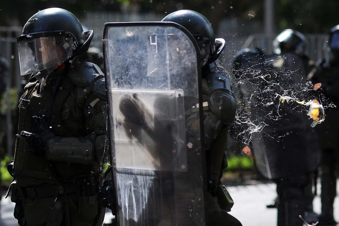 Riot police officer carrying a shield gets hit by an egg, as demonstrators rally outside the congress building to protest against a law being debated that would increase quotas for industrial fishing companies, in Valparaiso, Chile March 25, 2025. REUTERS/Pablo Sanhueza TPX IMAGES OF THE DAY