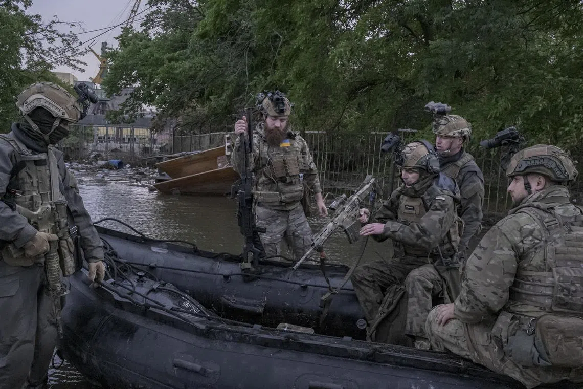 Ukrainian soldiers board a dinghy to patrol an area flooded by the destruction of the Kakhovka dam, in Kherson, Ukraine, Sunday, June 11, 2023. A Russian official and military bloggers said Sunday, June 18, that KyivÕs forces had retaken another village in their fight to recapture territory, a claim the Russian Defense Ministry denied. (Mauricio Lima/The New York Times)