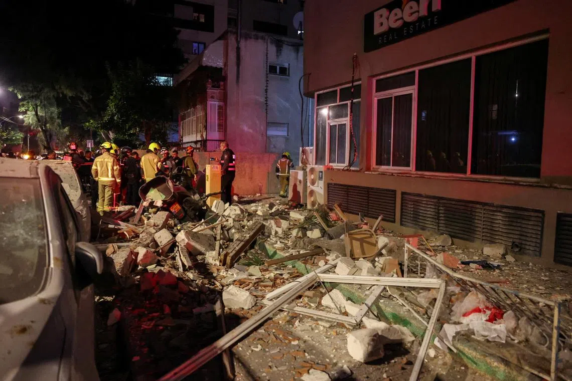 Emergency personnel inspect damage in a building following an Iranian projectile strike, amid the U.S.-Israeli conflict with Iran,  in Ramat Gan, Israel, March 18, 2026. REUTERS/Nir Elias