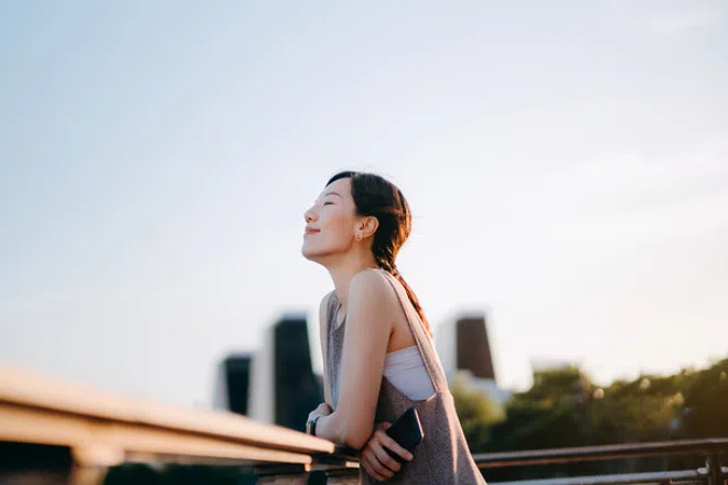 A woman who is feeling at peace and smiling into the distance