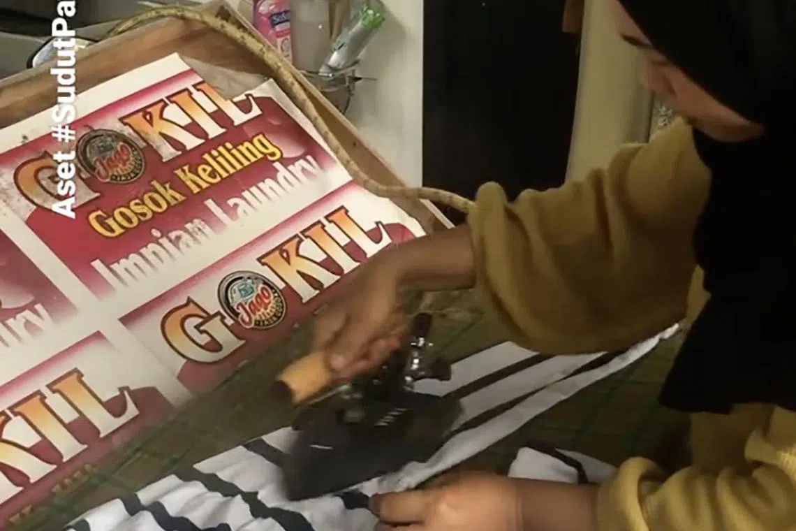 Using a makeshift wooden board attached to the front of her motorcycle, Madam Desri Muliati goes around homes in West Sumatra, ironing clothes for people.