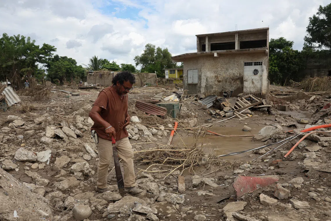 A man walks through mud and debris following torrential rains, in Poza Rica, Mexico, October 15, 2025. REUTERS/Henry Romero     TPX IMAGES OF THE DAY