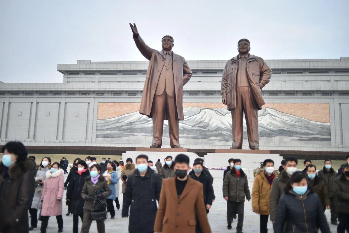 People visit the statues of North Korea's former president Kim Il Sung and chairman Kim Jong Il on Mansu Hill on the occasion of the lunar new year in Pyongyang on January 22, 2023. (Photo by KIM Won Jin / AFP)