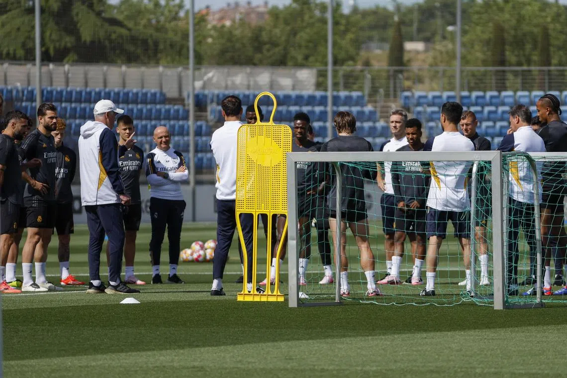 Real Madrid head coach Carlo Ancelotti (in cap) talks to his players during a training session ahead of the Champions League final against Borussia Dortmund.