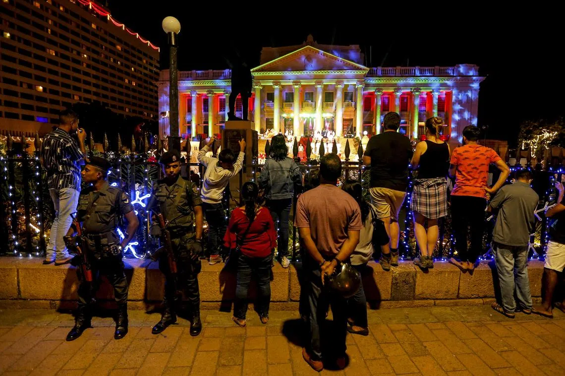 People enjoy Christmas illuminations and decorations in front of the Presidential Secretariat building in Colombo.