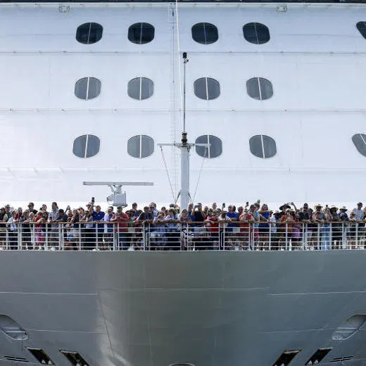 Tourists standing on deck as the cruise ship Brilliance of the Seas enters the Miraflores locks of the Panama Canal.