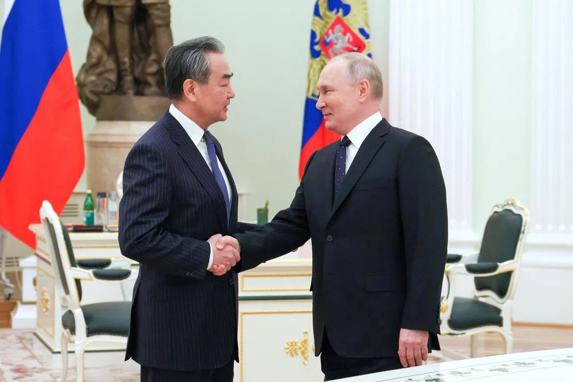 Mr Vladimir Putin (right) met with Mr Wang Yi in Moscow to “strengthen and deepen” ties between both countries, on Feb 22.