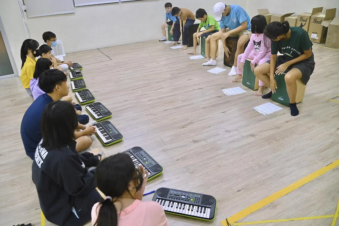 Students volunteers and children playing music at MorningStar Sengkang on 11 May 2023 . 
Story on CareNights, an evening support programme for lower-income children aged 6 to 14 years from 6 pm to 10 pm on weekdays, whose parents need caregiving respite or have to work shifts or take up upgrading courses