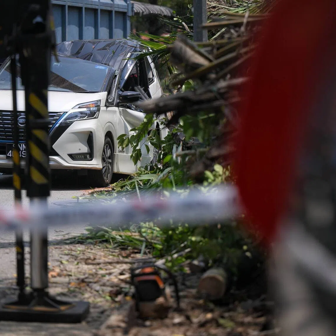 A white car which had the passenger side of its roof crushed by the fallen tree, driven by private hire driver Saiful, 60.