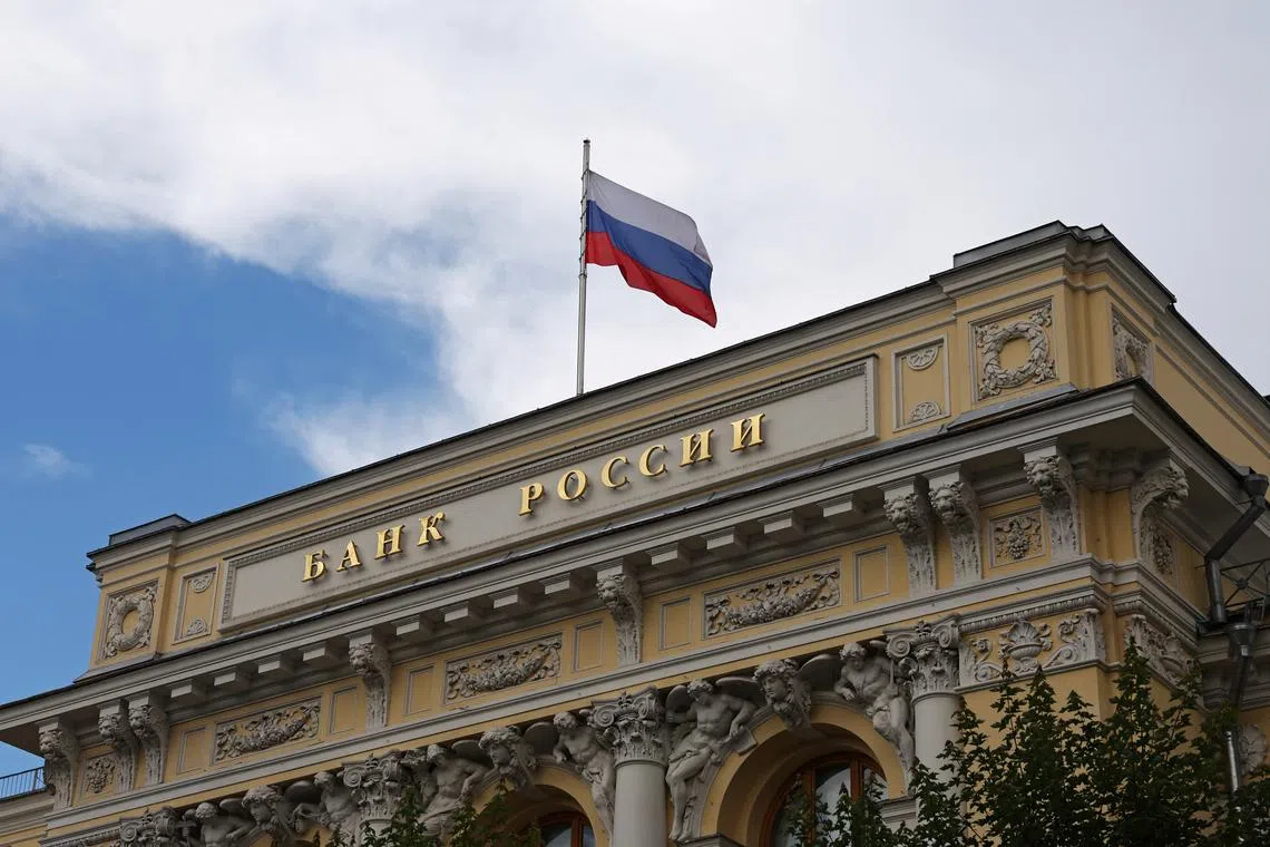 FILE PHOTO: A Russian state flag flies over the Central Bank headquarters in Moscow, Russia July 24, 2025. The sign reads: \"Bank of Russia\". REUTERS/Evgenia Novozhenina/File Photo