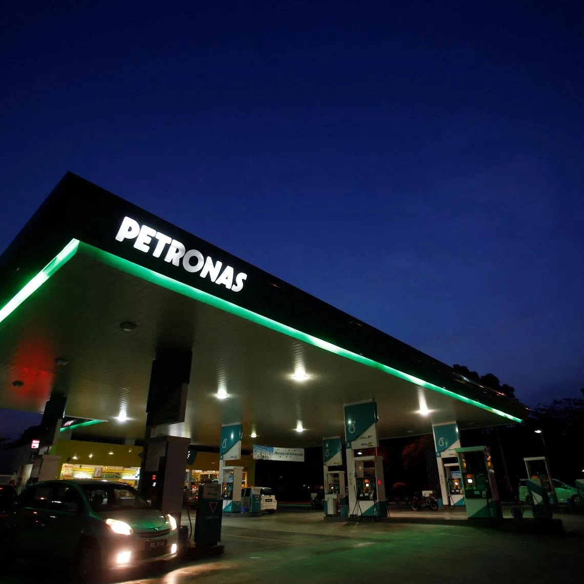 FILE PHOTO: A motorist pumps petrol at a Petronas gas station in Putrajaya outside Kuala Lumpur August 26, 2013.  REUTERS/Bazuki Muhammad/File Photo