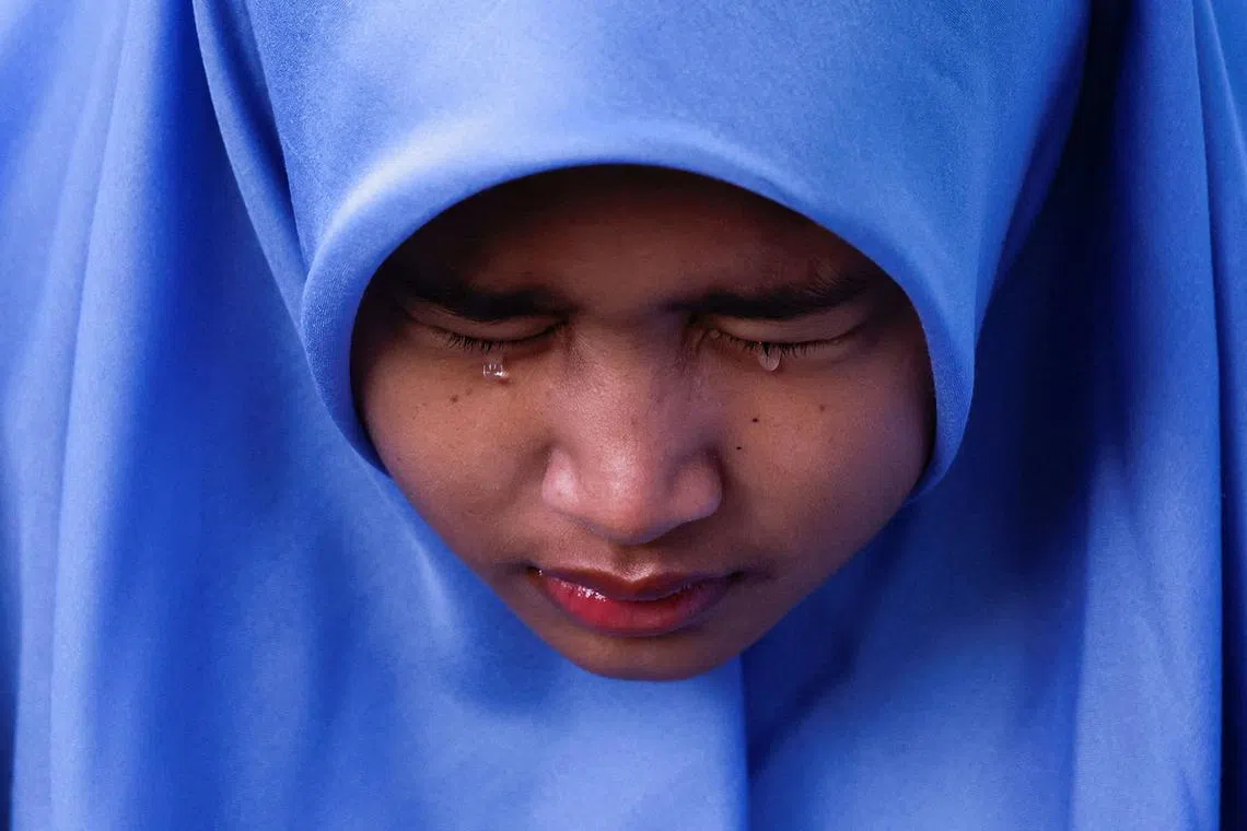 Aisha Rana Zhafirah reacts while visiting the Ulee Lheue mass grave, where victims of the 2004 Indian Ocean tsunami are buried, in Banda Aceh, Aceh, Indonesia, December 26, 2024. REUTERS/Willy Kurniawan TPX IMAGES OF THE DAY