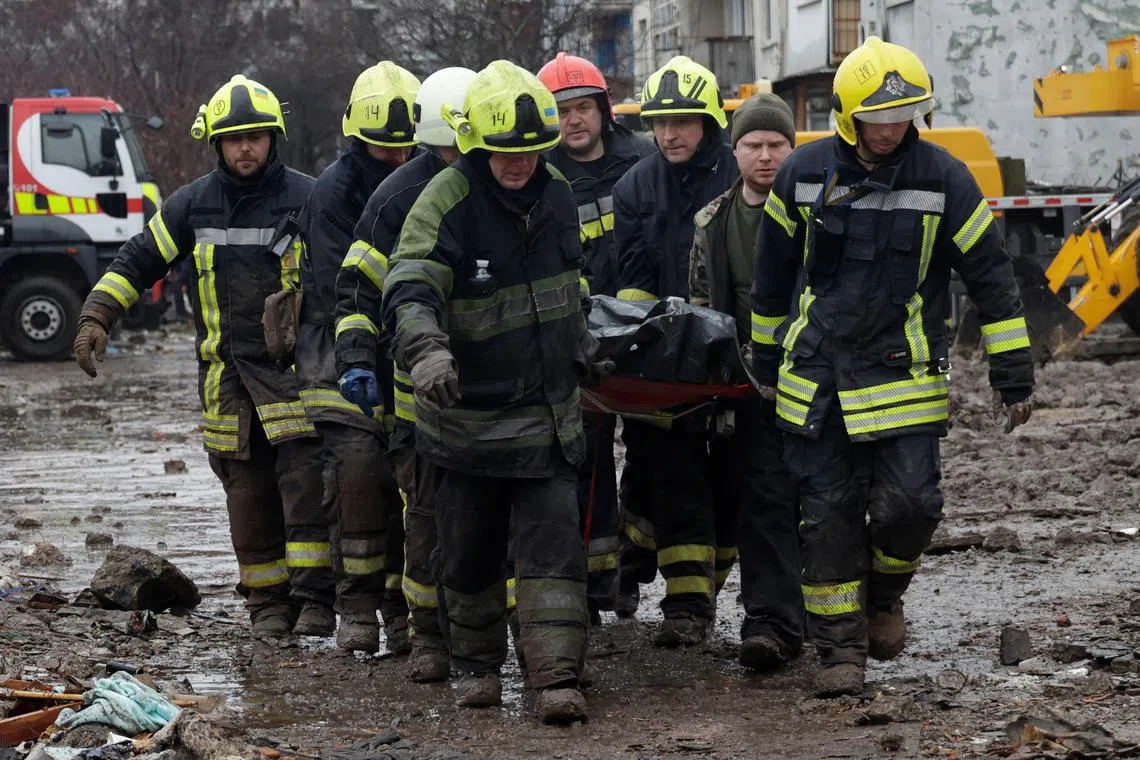 Rescuers carrying the body of a person found under the debris of an apartment building hit by a Russian missile strike, in  Poltava, Ukraine, on Feb 1.