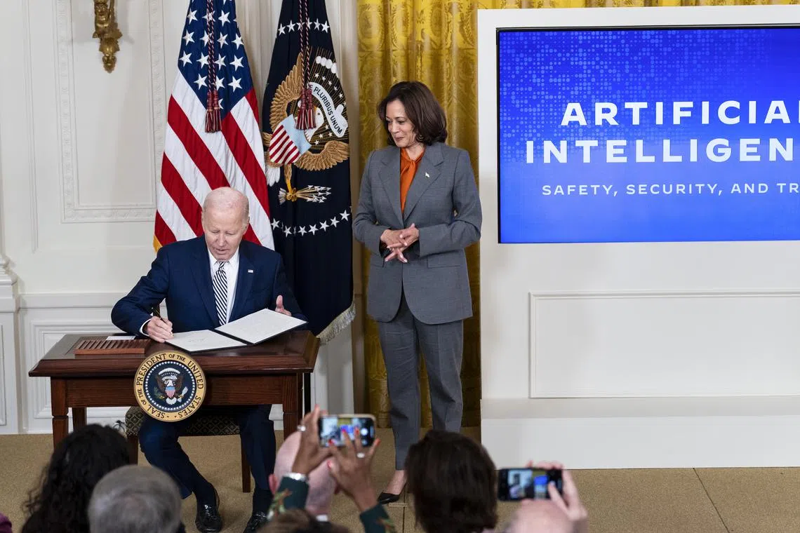 US President Joe Biden sign an executive order with Vice President Kamala Harris during an event on development and use of AI.