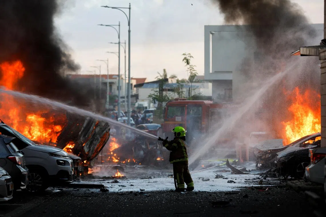 A firefighter working to extinguish flames after a rocket attack launched from the Gaza Strip, in  Ashkelon, Israel, on Oct 7.