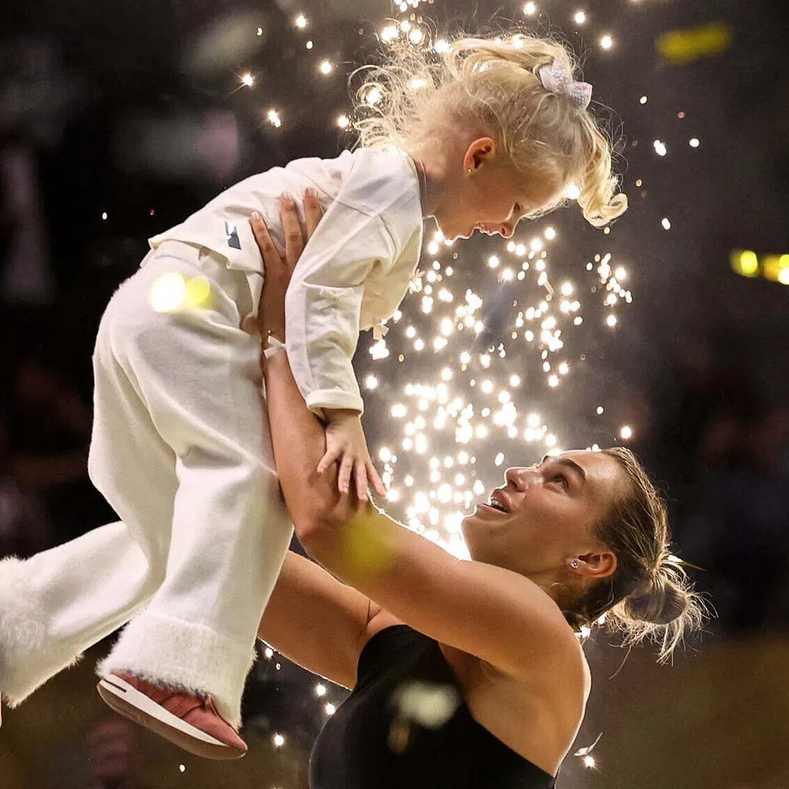 TOPSHOT - Belarus' Aryna Sabalenka interacts with her goddaughter Nicole during the trophy ceremony following her defeat in her Battle of the Sexes exhibition tennis match against Australia's Nick Kyrgios in Dubai on December 28, 2025. (Photo by Amr Alfiky / POOL / AFP)