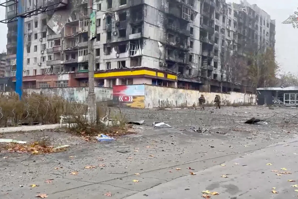 Russian servicemen walk past a damaged apartment building in Pokrovsk, Ukraine, in this still image taken from video released on November 20, 2025.  Russian Defence Ministry/Handout via REUTERS