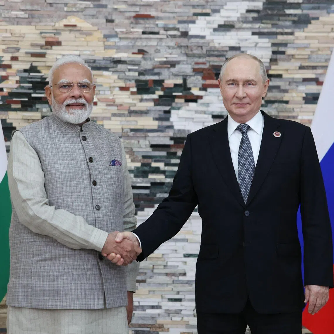 Indian Prime Minister Narendra Modi (left) shaking hands on the sidelines of the Shanghai Cooperation Organisation summit on Aug 31 with Russian President Vladimir Putin.