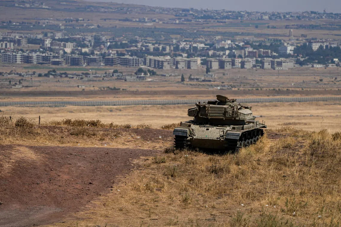 FILE PHOTO: An Israeli tank stands in position near the ceasefire line between the Israeli-occupied Golan Heights and Syria, on its Israeli side August 20, 2026. REUTERS/Ayal Margolin/File Photo