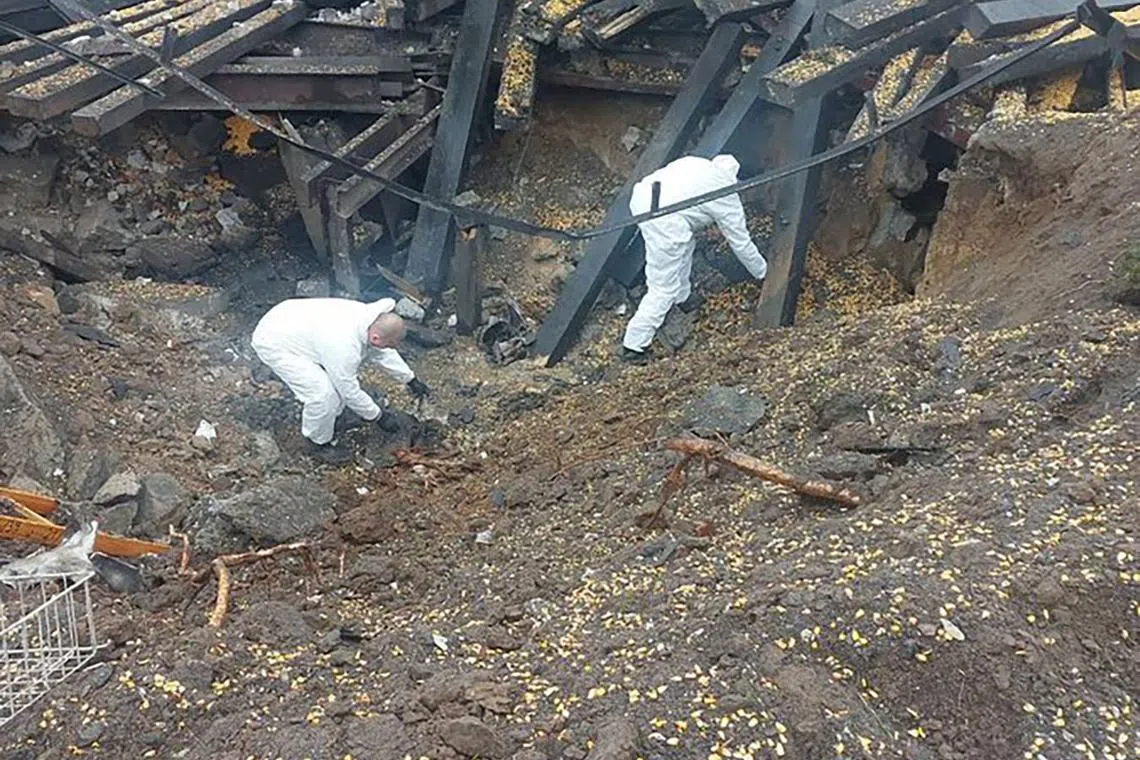 This handout photo taken on Nov 16, 2022 shows forensic experts investigating the site where a missile hit the southeastern Polish village of Przewodow, some 6km from the Ukrainian border.