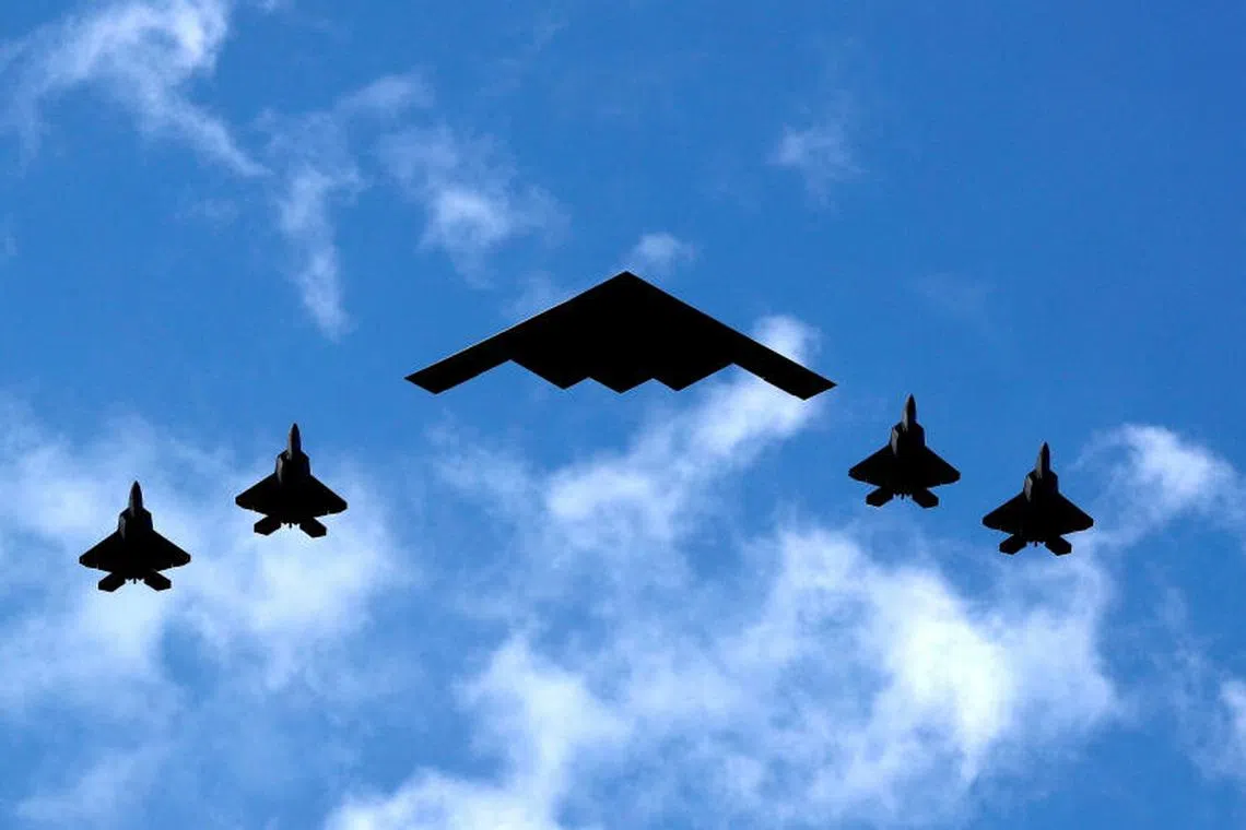 A US Air Force B-2 Spirit Stealth Bomber (centre) flanked by four F-22 Raptor fighter planes during a flyover down the Hudson River and New York Harbour past York City, and New Jersey, US.