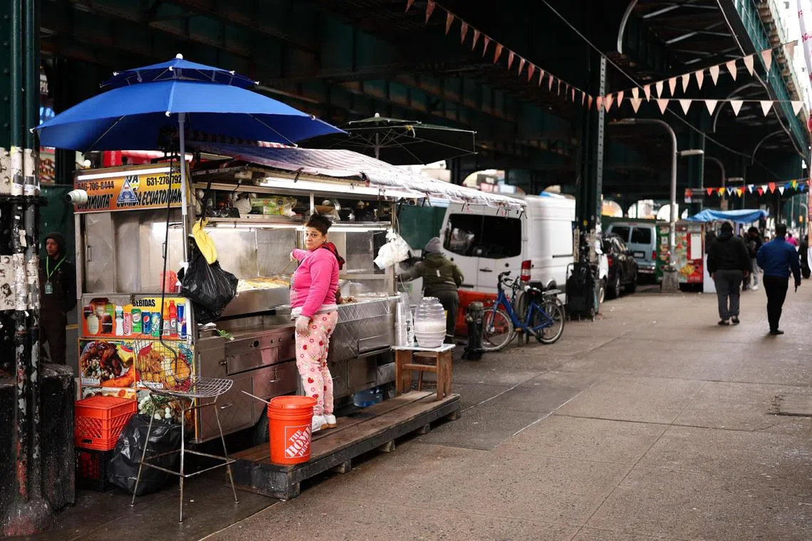 A woman sells food on a street in the Corona Plaza area in the Queens borough of New York City on March 20.