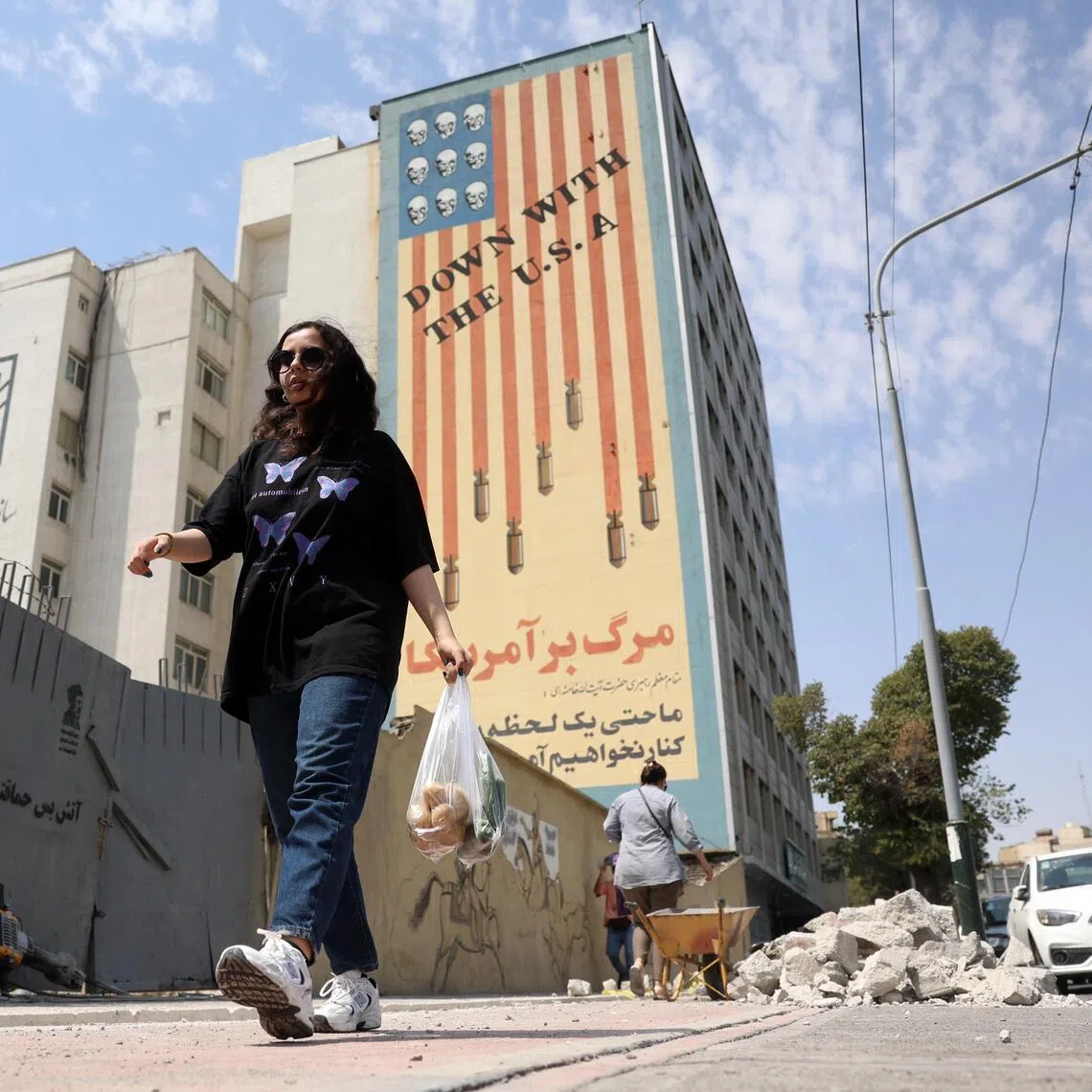 An Iranian woman walking past an anti-US mural in the Iranian capital, Tehran, on Aug 17.