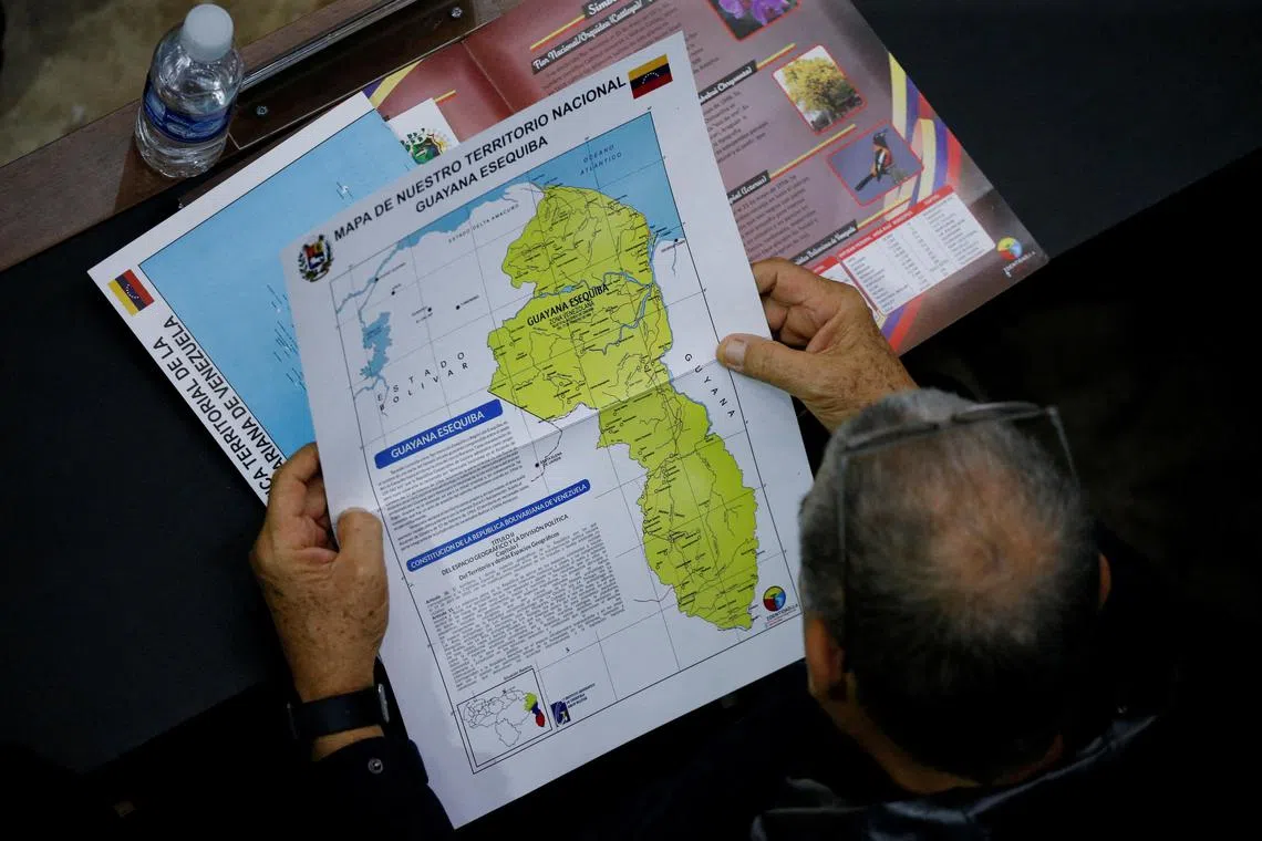 A Venezuelan politician holds a map showing the disputed Essequibo region as part of Venezuela.