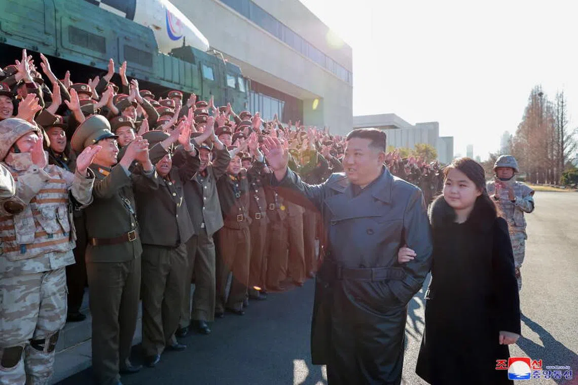 An undated photo released by the official North Korean Central News Agency (KCNA) on Nov 27, 2022, shows North Korean leader Kim Jong Un (second from right, walking with his daughter - presumed to be his second child, Ju-ae (right) - during a photo session with the contributors to the successful test-fire of new-type ICBM Hwasongpho-17 at an undisclosed location in North Korea.