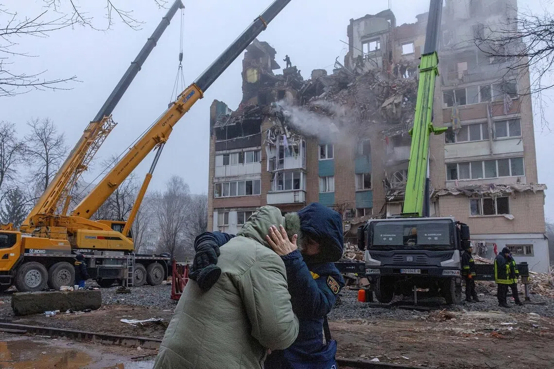 A psychologist comforts a resident in front of an apartment building that was hit yesterday by a Russian missile, amid Russia's attack on Ukraine, in Ternopil, Ukraine, November 20, 2025. REUTERS/Thomas Peter TPX IMAGES OF THE DAY