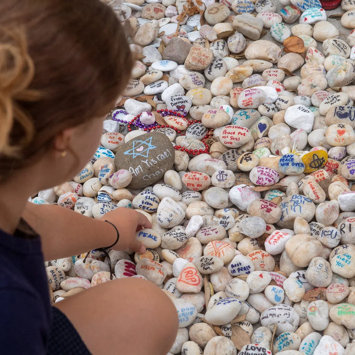 FILE PHOTO: A visitor places a pebble at a memorial site in remembrance to the lives lost during the Bondi Beach mass shooting on December 14, 2025, in Sydney, Australia, January 16, 2026. REUTERS/Jeremy Piper/File Photo