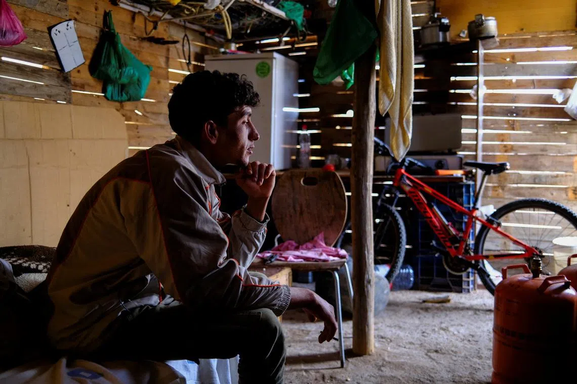 Moroccan migrant Abdelmoujoud Erra, 27, sits on a bed at a shack friend’s near the site where the place they lived burned in a fire in Nijar, province of Almeria Spain, April 21, 2026. Erra says \"Documents needed for a migration amnesty were saved because they were stored at a Red Cross facility\". REUTERS/Nacho Doce
