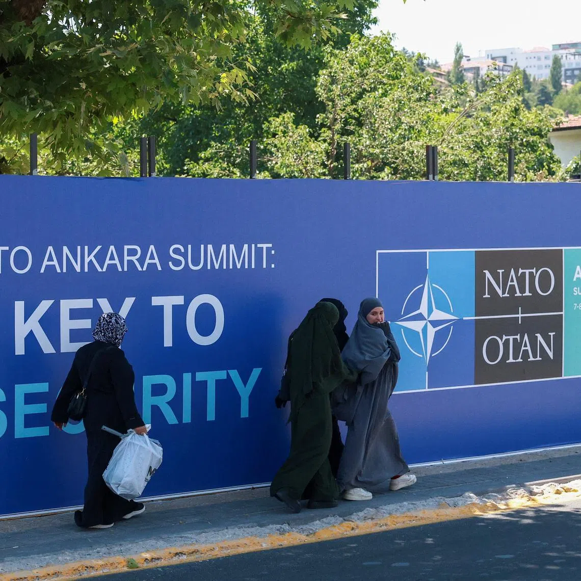 People walk past billboards built for upcoming NATO summit in Ankara, Turkey, July 1, 2026. REUTERS/Efekan Akyuz