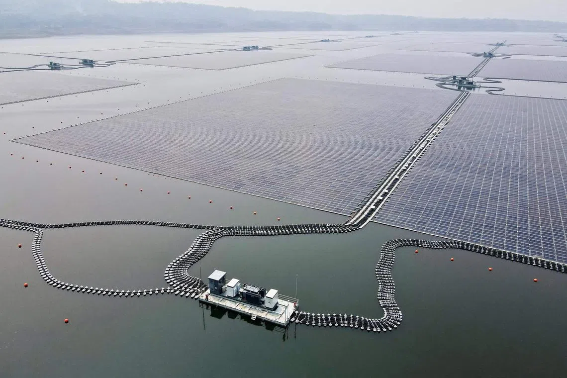 TOPSHOT - This aerial picture shows the newly built floating solar power plant on the water that can generate 192 mega watts of peak electricity in cooperation between the Indonesian government and Masdar from the UAE, at Cirata Reservoir, West Java, on November 9, 2023, shortly before being inaugurated by President Joko Widodo. (Photo by BAY ISMOYO / AFP)