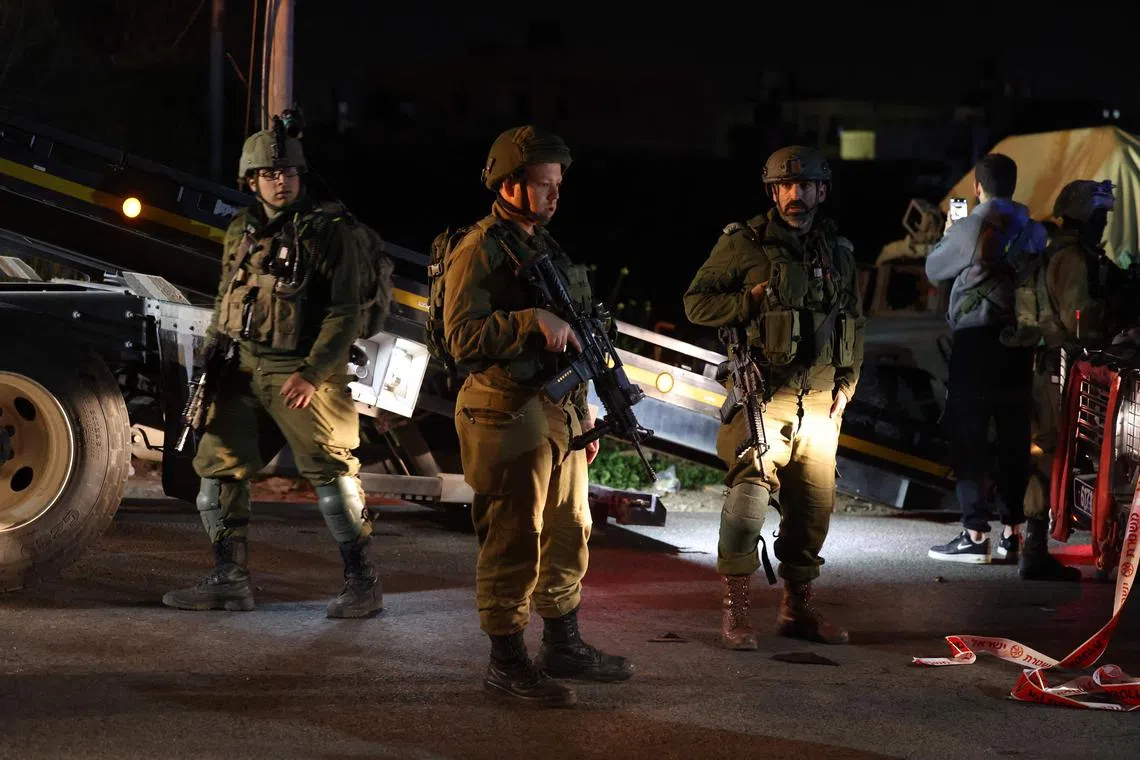 Israeli soldiers gather at the site of a ramming attack near the town of Beit Ummar north of Hebron, on April 1, 2023. (Photo by AHMAD GHARABLI / AFP)