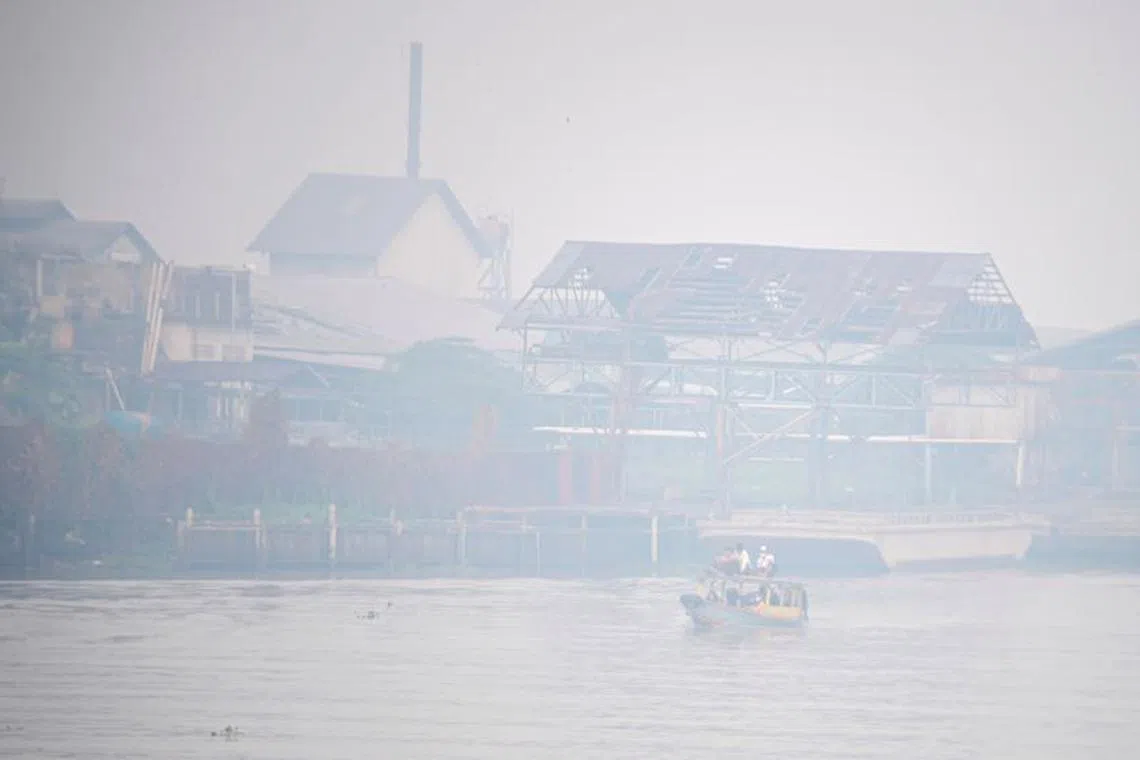 FILE PHOTO: Students ride a wooden boat through the Ogan river, which is covered by smog due to wildfires, in Palembang, South Sumatra province, Indonesia, September 30, 2023, in this photo taken by Antara Foto. Antara Foto/Nova Wahyudi/ via REUTER/File photo