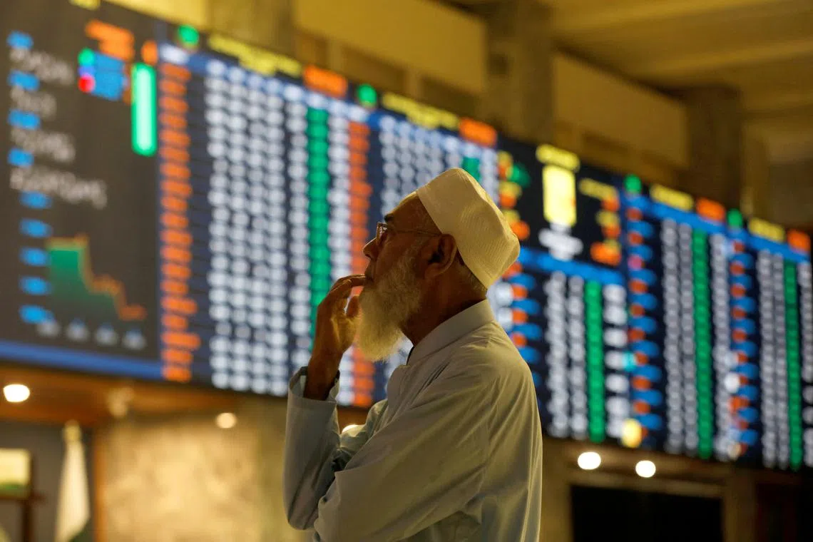 A stock broker reacts while monitoring the market on the electronic board displaying share prices during trading session at the Pakistan Stock Exchange, in Karachi, Pakistan July 3, 2023. REUTERS/Akhtar Soomro/File Photo