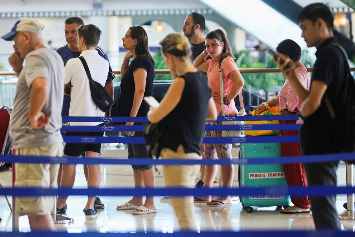 Stranded passengers stand in line at the Qatar Airways customer service at I Gusti Ngurah Rai International Airport after flights to Doha, Dubai, and Abu Dhabi were cancelled following strikes on Iran launched by the United States and Israel, in Kuta, Bali, Indonesia, March 1, 2026. REUTERS/Johannes Christo