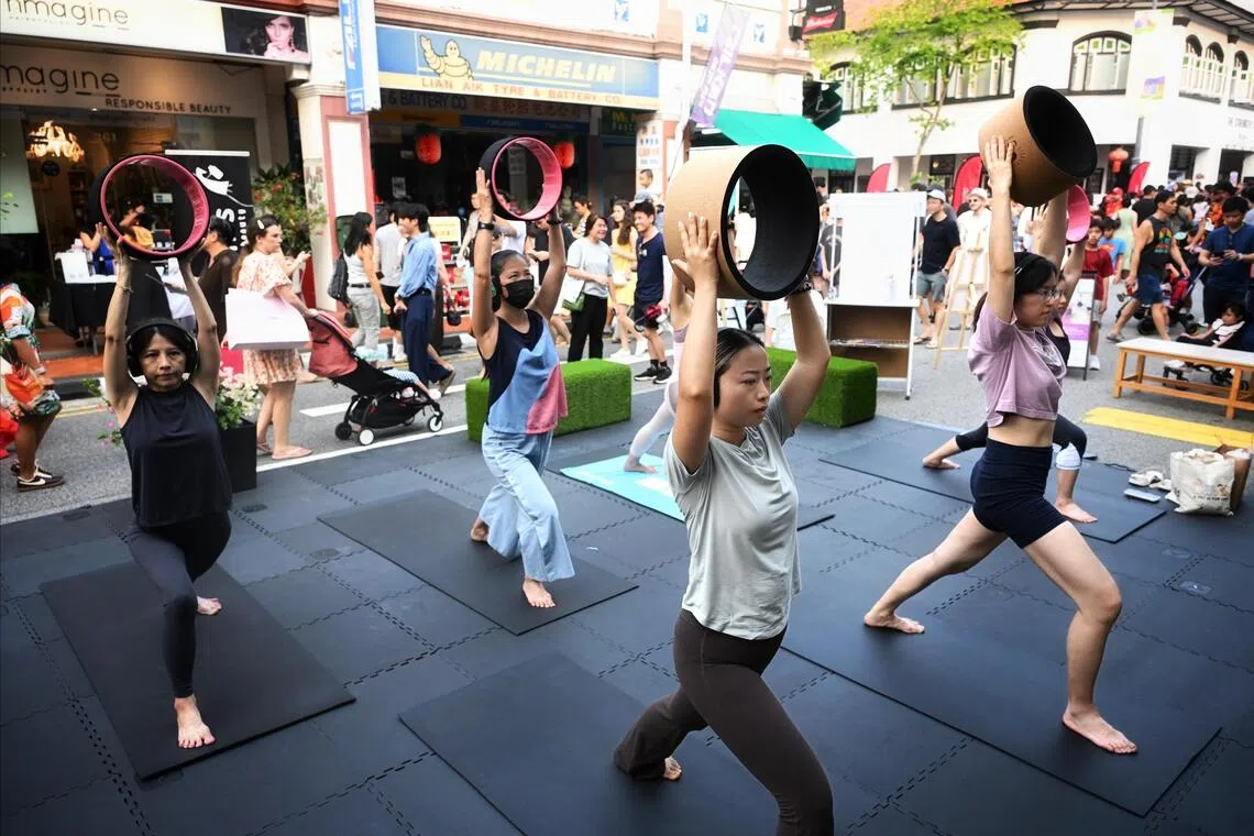 People doing wheel yoga on the streets at the Joo Chiat Car-Free Day on Oct 3.