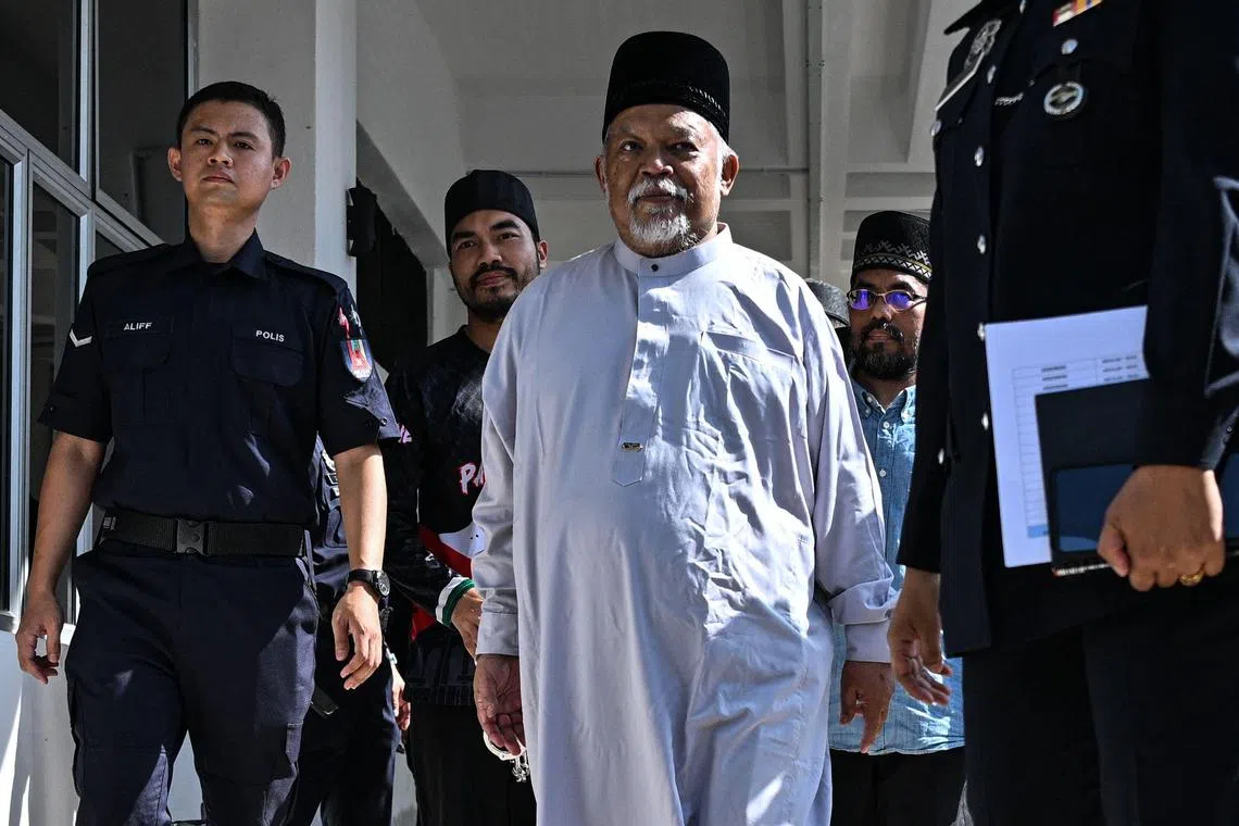 Nasiruddin Mohd Ali (in white), CEO of deviant Islamic group Global Ikhwan Services and Business Holdings (GISB), arriving at the Magistrate Court in Selayang,  outskirts of Kuala Lumpur, on Oct 23. 