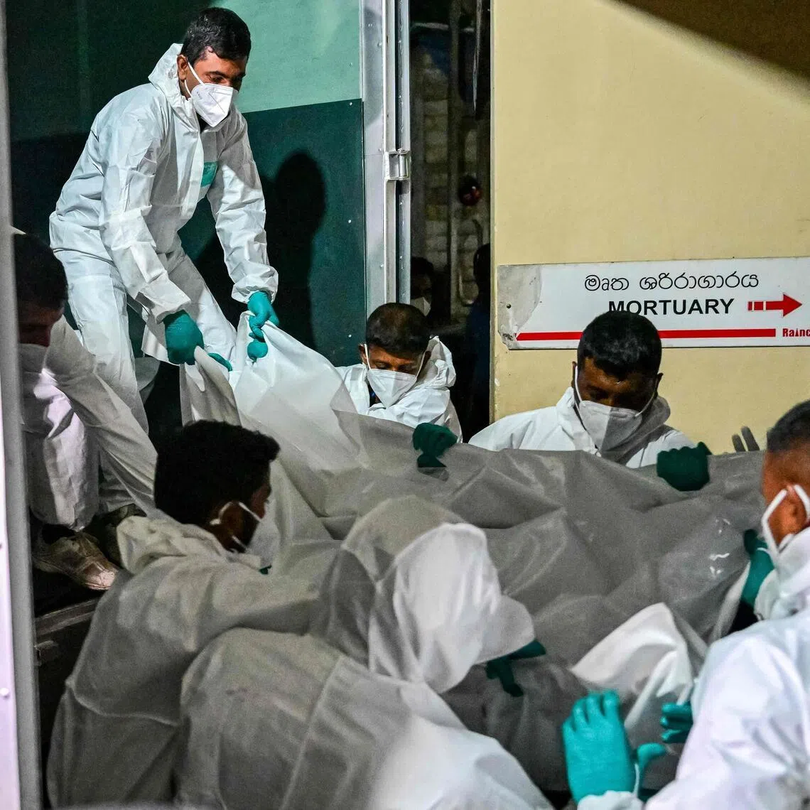 Healthcare workers in Sri Lanka carrying the bodies of Iranian sailors who died when a US torpedo hit their warship off Sri Lanka's southern coast on March 4. 