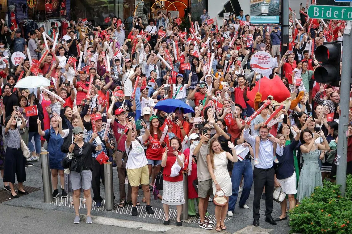 Supporters at the junction of Bideford Road and Orchard Road cheering on the Olympians during the One Team Singapore celebratory parade on Aug 14, 2024. ST PHOTO: KEVIN LIM dgbus14
