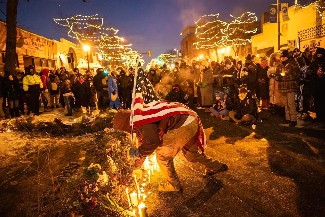 Demonstrators place candles and flowers at a makeshift memorial at the site where Alex Jeffrey Pretti was killed.