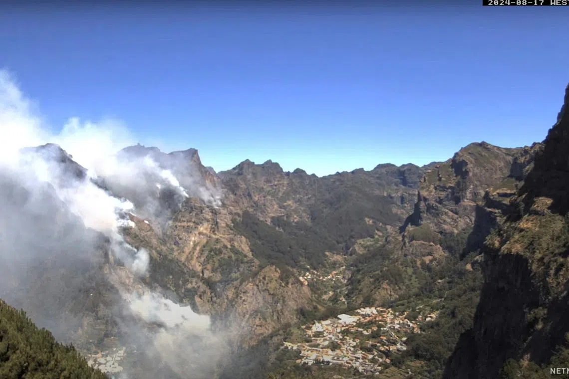 FILE PHOTO: Smoke rises as a wildfire burns at Curral das Freiras, Madeira, Portugal August 17, 2024, in this screen grab obtained from a social media video. netmadeira.com/via REUTERS/File Photo