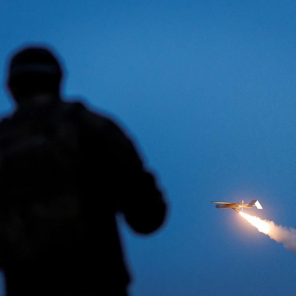 A service member of the 414th Separate Unmanned Strike Aviation System Brigade ‘Magyar’s Birds’ of the Ukrainian Armed Forces looks at an FP-1 deep-strike drone as it launches for a combat mission, amid Russia’s attack on Ukraine, in an undisclosed location in Ukraine, in 2026.