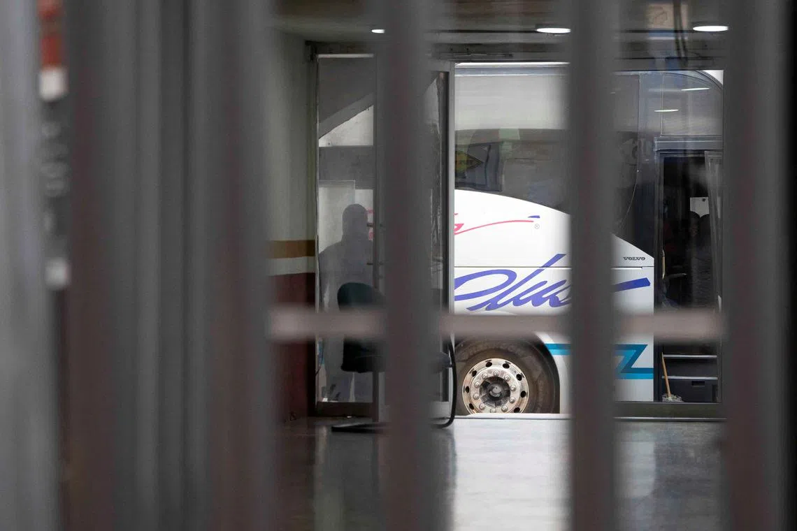A law enforcement officer surveils a bus used to transport deportees from the U.S. to Nogales, Sonora, Mexico, January 24, 2025. REUTERS/Rebecca Noble/File Photo