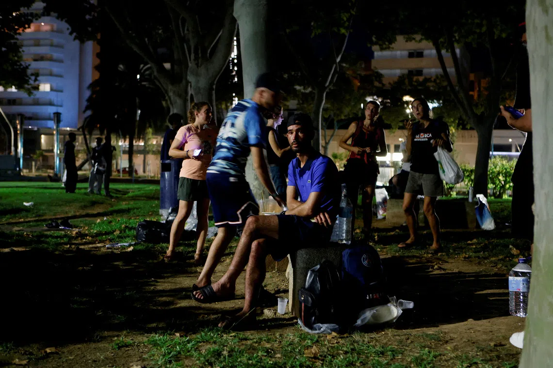 An Algerian migrant sits in a public park after arriving from Algeria earlier in the day, as more than 30 boats carrying about 600 irregular migrants have reached the Balearic Islands since Monday, according to officials, in Palma de Mallorca, Spain, August 12, 2025. REUTERS/Francisco Ubilla